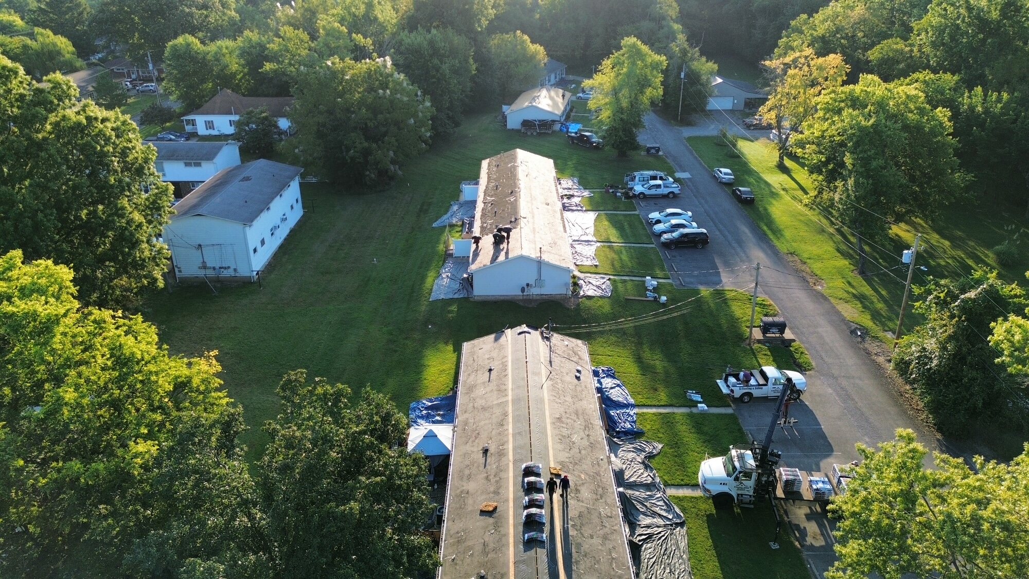 Roofers working near the ridge during a roof replacement